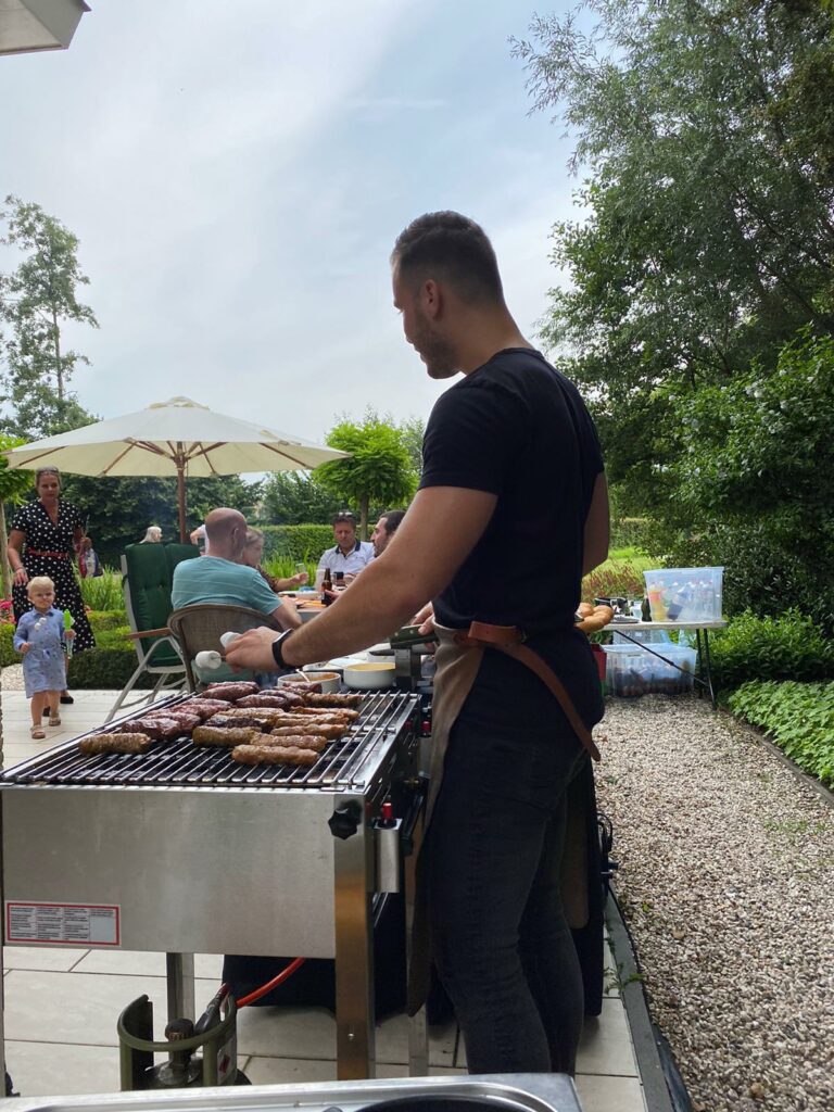 barbecue chef met vlees op de grill in tuin