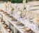 Long dinner table decorated with flaxen cloth and white candles luxe gedekte tafel voor een bruiloft